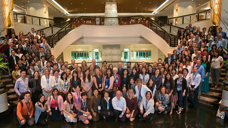 Large corporate team photo taken on a hotel staircase in Bangkok