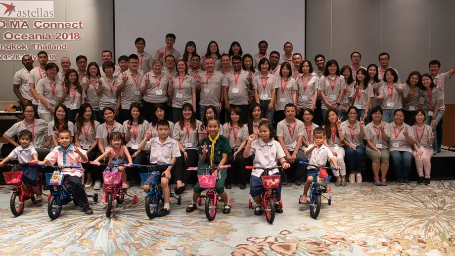 Corporate group with children after a build-a-bike CSR event in Bangkok