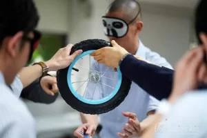 Blindfolded participants building a bicycle for kids