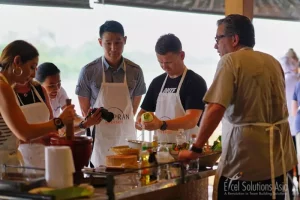 Collaborative team passionately preparing a spicy somtam, a traditional Thai dish, with dedication and precision.