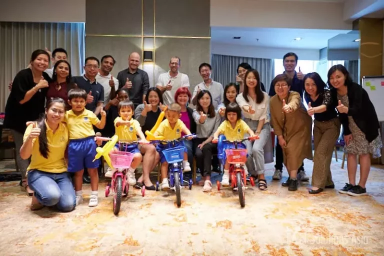 Corporate group with children on a build a bike CSR team building event