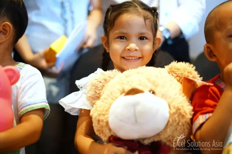 Little girl hugging a big teddy bear