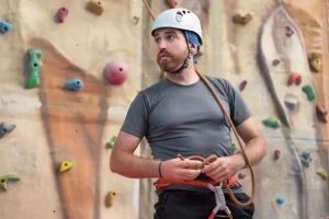 Man participates in a corporate rock climbing event
