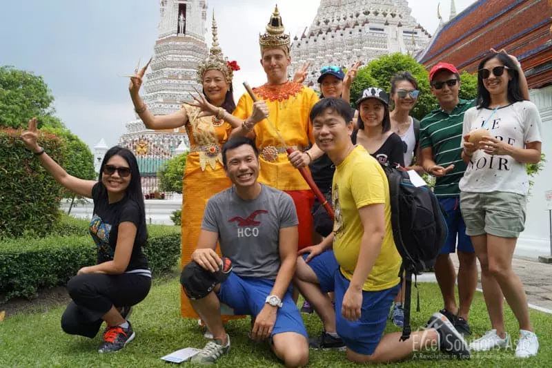 A team of competitors experiencing Bangkok's famous Wat Arun temple and dress in Thai costume during the Amazing Race.