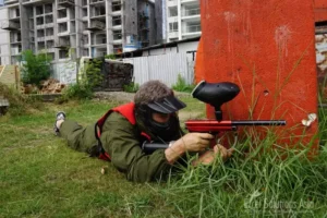 A player taking aim with utmost concentration, ready to unleash a precise and powerful shot in the exhilarating world of paintball in Thailand.