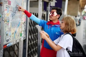 Engaged superhero team in Bangkok, Thailand, demonstrating leadership by giving directions on a map during a team-building event