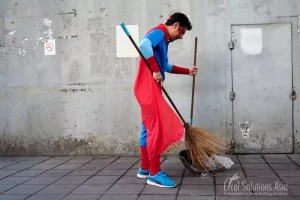 Superhero team actively contributing to the community in Bangkok, Thailand, by sweeping the streets during a team-building event.