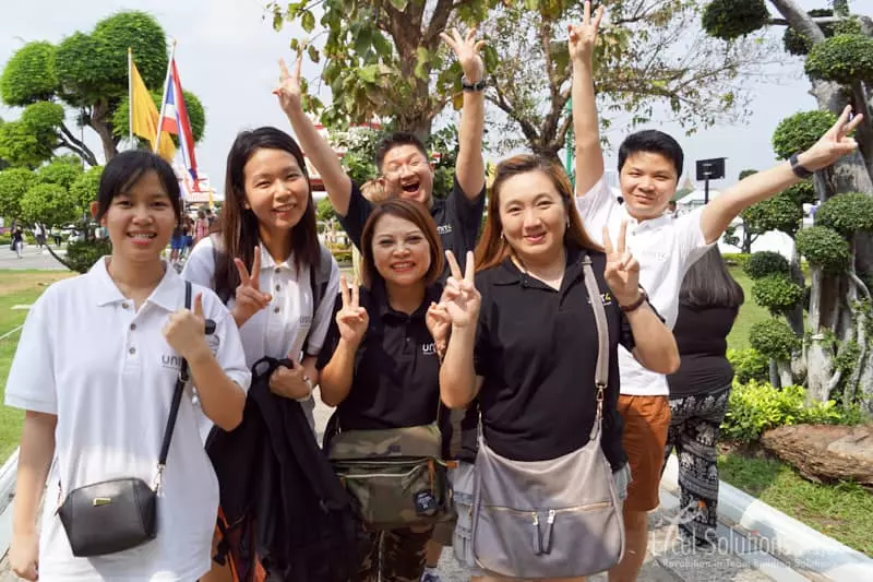 Happy team members participating in a scavenger hunt in Bangkok, Thailand. They are smiling and full of enthusiasm as they work together.